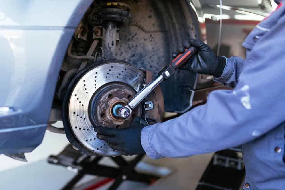 Mechanic repairing brake pads with spanner in Gladstone